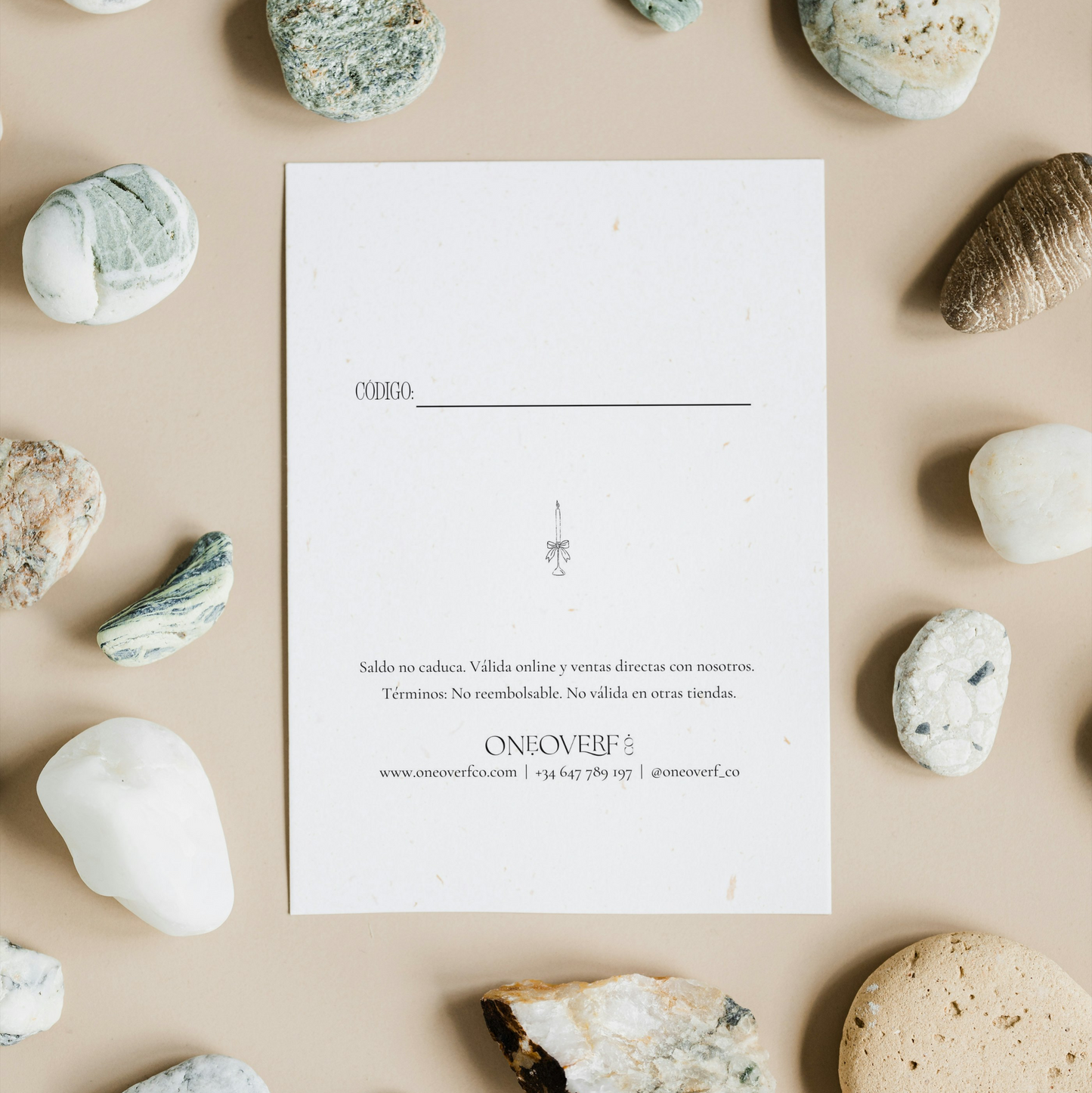 White card with text on a beige background surrounded by various stones